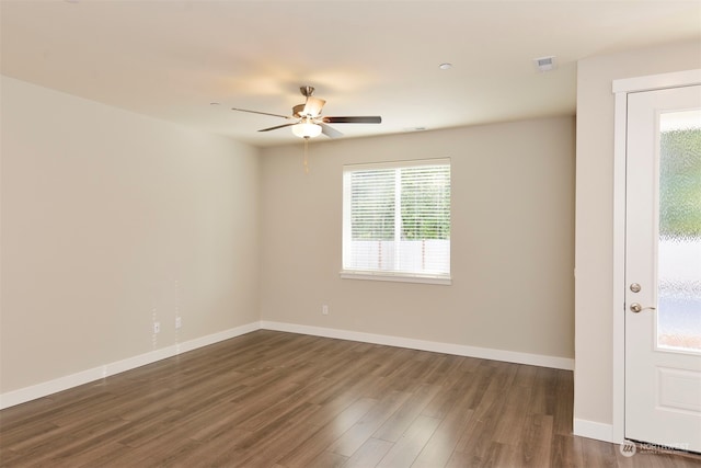 spare room featuring dark wood-type flooring and ceiling fan