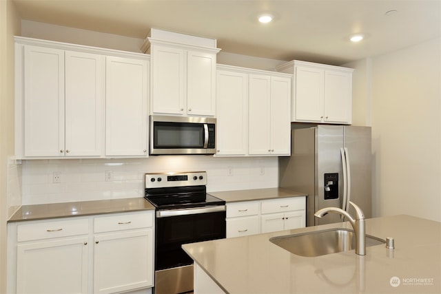 kitchen featuring white cabinetry, appliances with stainless steel finishes, sink, and decorative backsplash