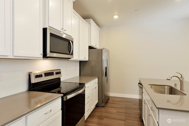 kitchen featuring sink, dark wood-type flooring, white cabinetry, stainless steel appliances, and decorative backsplash