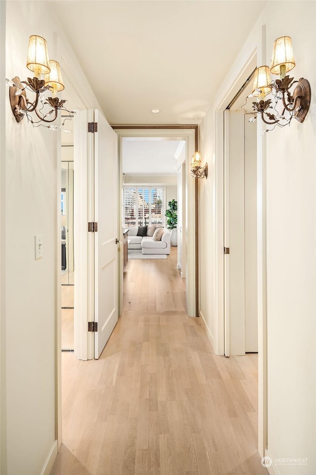 hall with a chandelier and light hardwood / wood-style floors