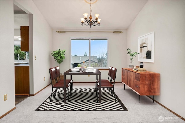 dining room with carpet flooring, plenty of natural light, a notable chandelier, and baseboards