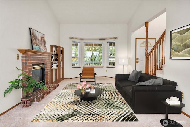 living area with a brick fireplace, baseboards, stairway, and light colored carpet