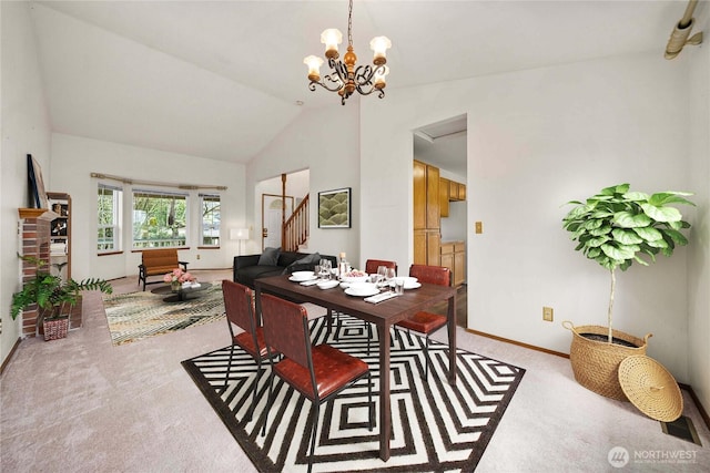 dining space featuring a chandelier, high vaulted ceiling, light colored carpet, baseboards, and stairway