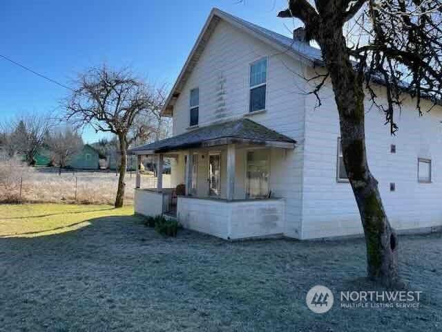 view of side of property with a yard and a porch