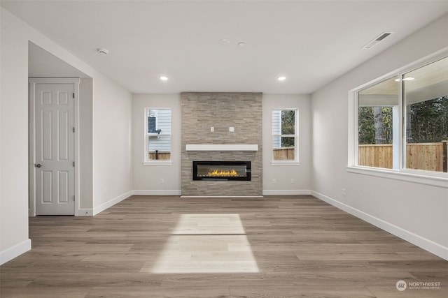 unfurnished living room featuring a fireplace and light hardwood / wood-style floors