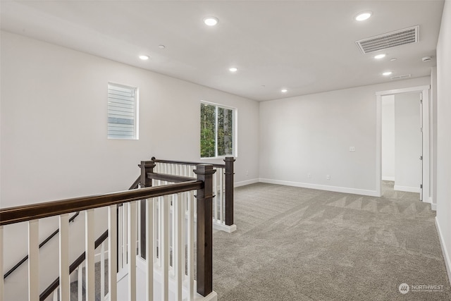 hall featuring light colored carpet