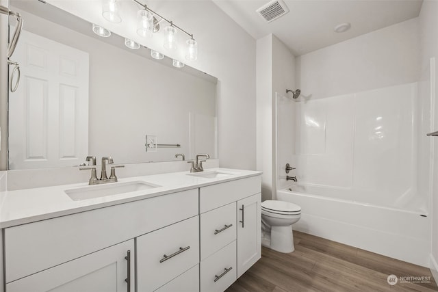 full bathroom with shower / washtub combination, hardwood / wood-style floors, vanity, and toilet