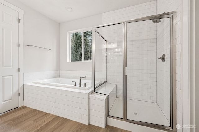 bathroom featuring wood-type flooring and separate shower and tub