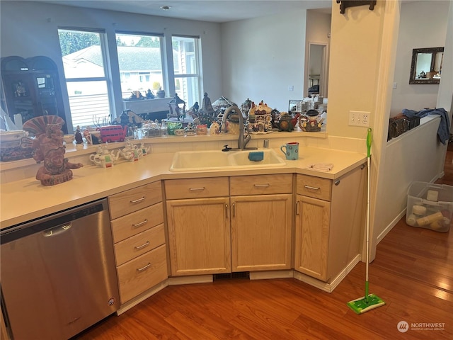 kitchen featuring light brown cabinetry, sink, stainless steel dishwasher, and hardwood / wood-style floors