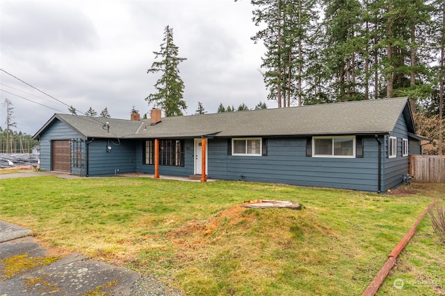 ranch-style home with a garage and a front lawn