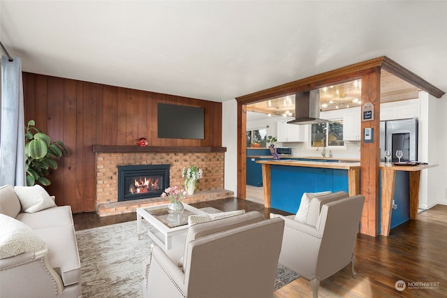 living room featuring a fireplace, dark hardwood / wood-style flooring, and wood walls