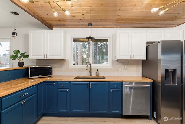 kitchen featuring sink, decorative light fixtures, stainless steel appliances, and white cabinets