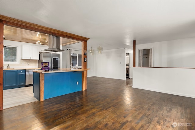 kitchen with blue cabinets, appliances with stainless steel finishes, dark hardwood / wood-style floors, island exhaust hood, and white cabinets