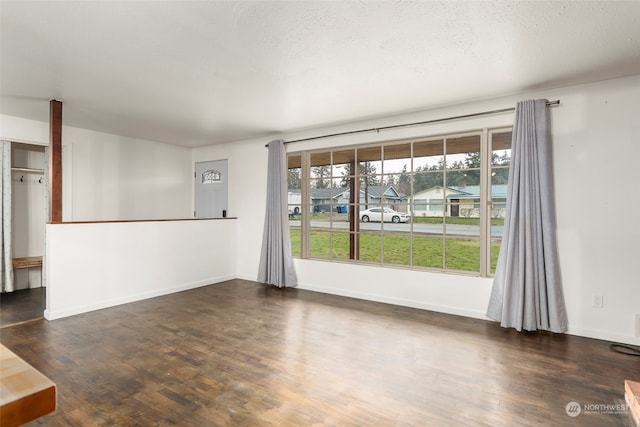 spare room with dark hardwood / wood-style flooring, plenty of natural light, and a textured ceiling