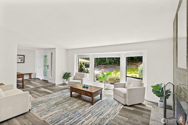 living area with baseboards and wood finished floors