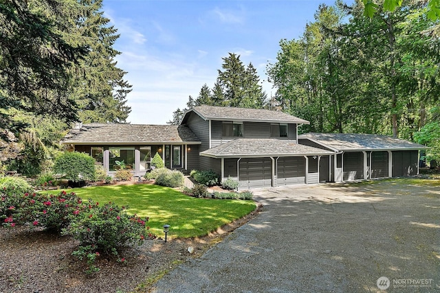 split level home featuring driveway, an attached garage, and a front lawn