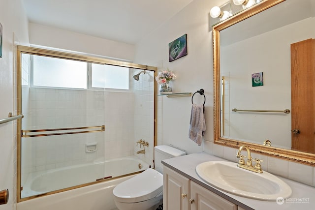 full bathroom featuring toilet, vanity, and bath / shower combo with glass door