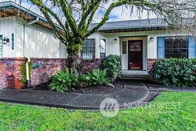 view of exterior entry featuring a yard