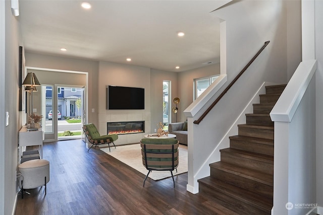 living room featuring plenty of natural light, dark hardwood / wood-style floors, and a fireplace