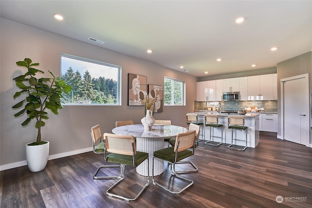 dining room with dark hardwood / wood-style floors and sink