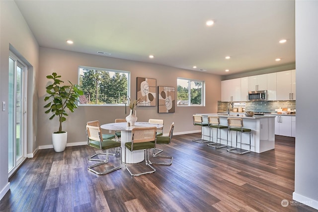 dining space with dark wood-type flooring and sink