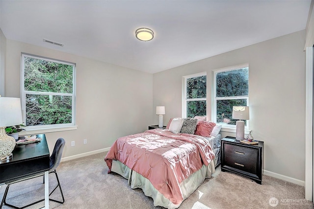 bedroom featuring visible vents, light carpet, and baseboards