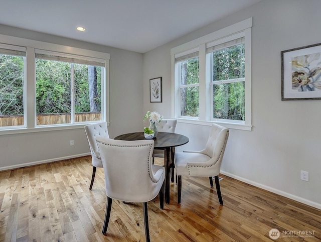 dining area featuring light wood finished floors and baseboards