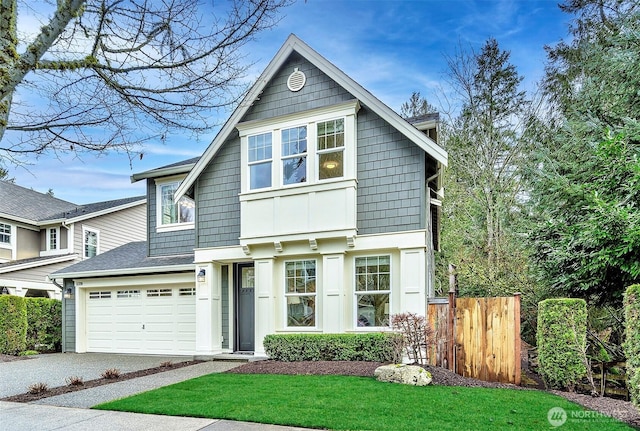 view of front of property featuring driveway, a garage, fence, and a front lawn