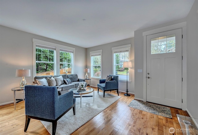 living area with baseboards and light wood finished floors