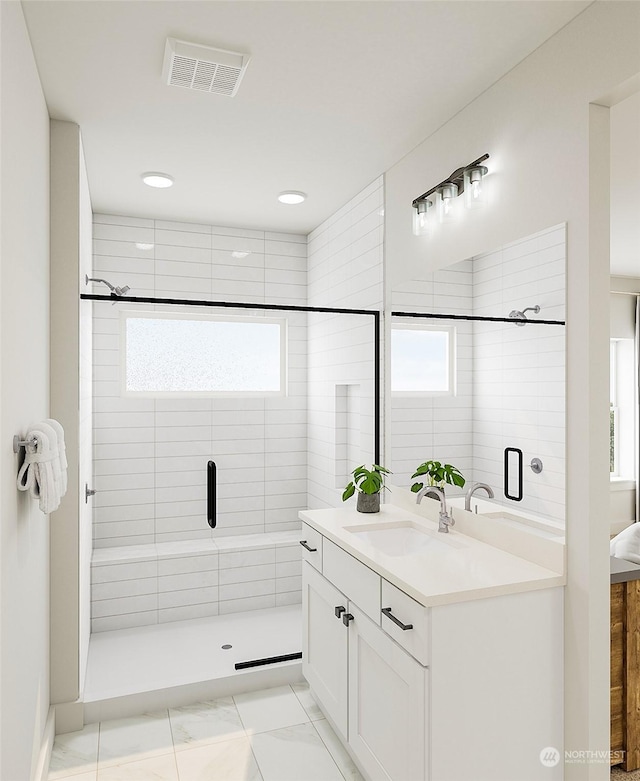 bathroom featuring vanity, a shower with door, and plenty of natural light