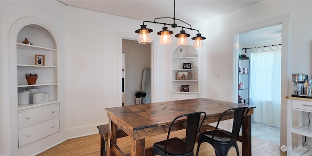 dining space with built in shelves and light hardwood / wood-style floors