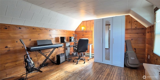 home office with lofted ceiling, wooden walls, a baseboard heating unit, and hardwood / wood-style floors