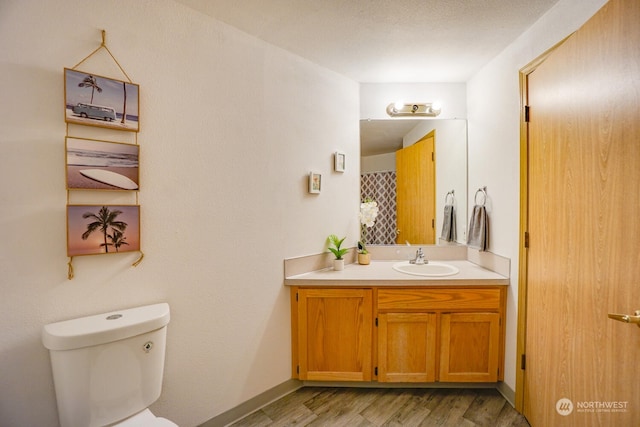 bathroom with vanity, hardwood / wood-style floors, and toilet