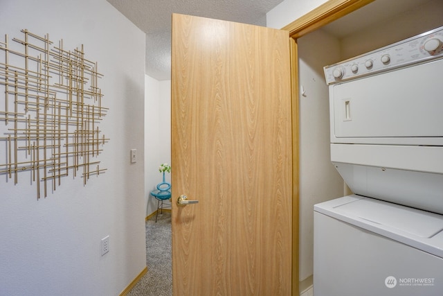 laundry area featuring stacked washer / drying machine, carpet flooring, and a textured ceiling