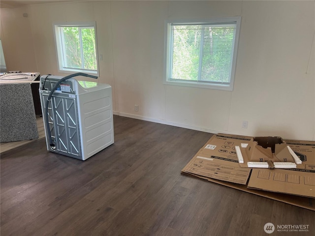 unfurnished living room featuring baseboards and wood finished floors