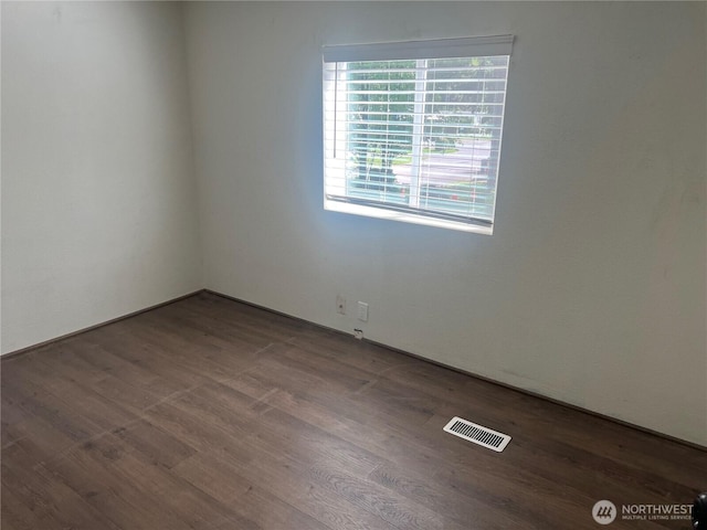 unfurnished room featuring visible vents and wood finished floors