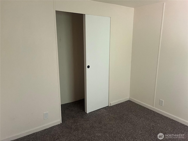 spare room featuring dark colored carpet