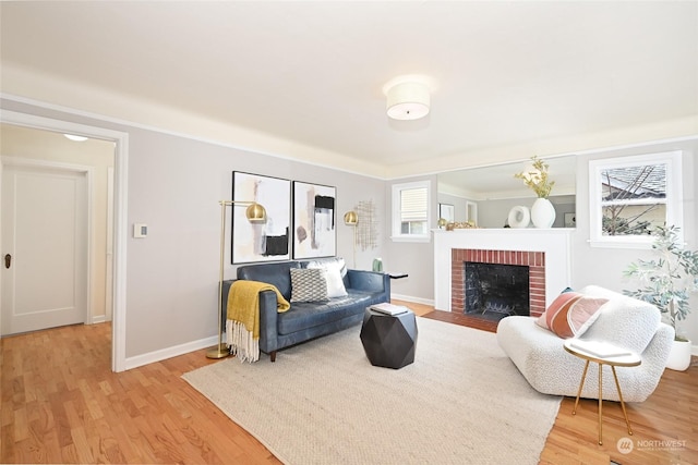 living room with a fireplace, light hardwood / wood-style flooring, and a wealth of natural light