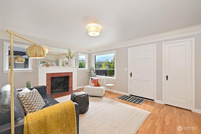 living room featuring light hardwood / wood-style floors and a brick fireplace