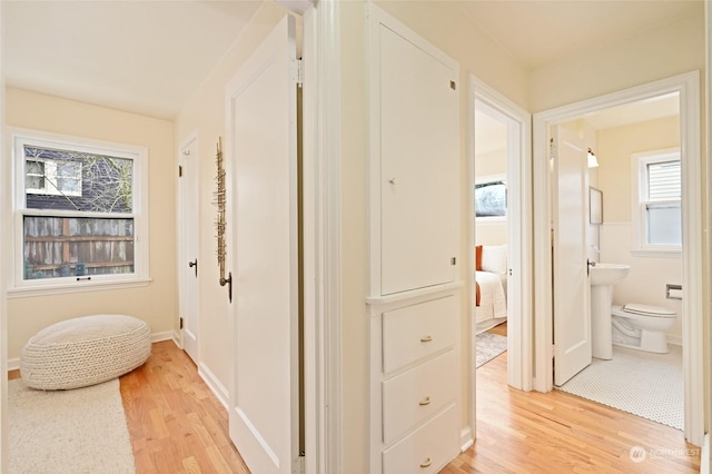 corridor with sink and light wood-type flooring