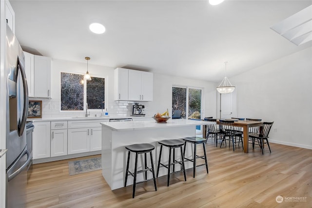 kitchen featuring white cabinetry, decorative light fixtures, and sink