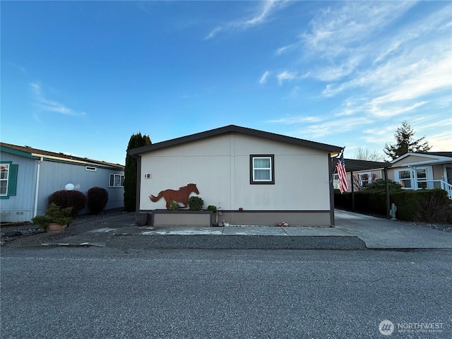 view of property exterior with a carport and concrete driveway