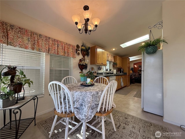 dining space featuring a skylight, baseboards, and a chandelier