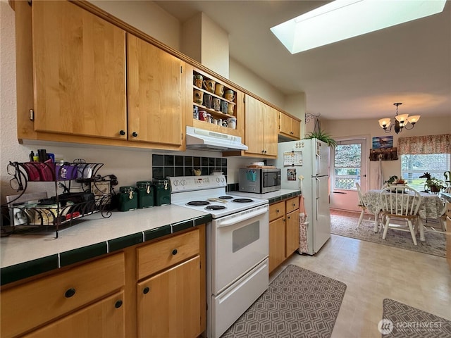 kitchen with a skylight, light floors, a chandelier, white appliances, and under cabinet range hood