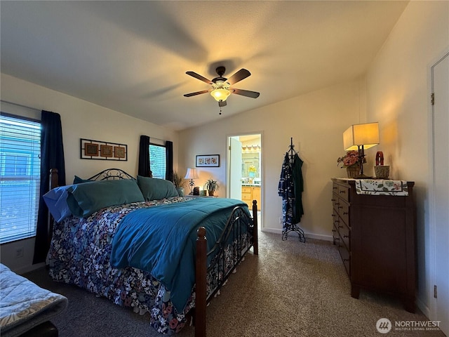 bedroom featuring carpet floors, vaulted ceiling, ceiling fan, ensuite bath, and baseboards