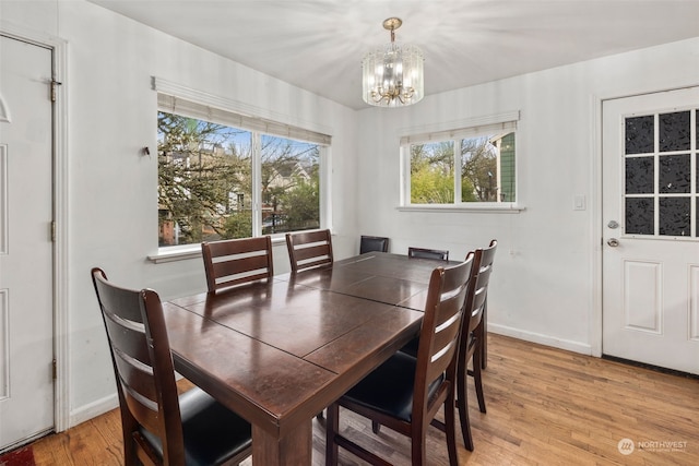 dining space featuring an inviting chandelier and light hardwood / wood-style floors