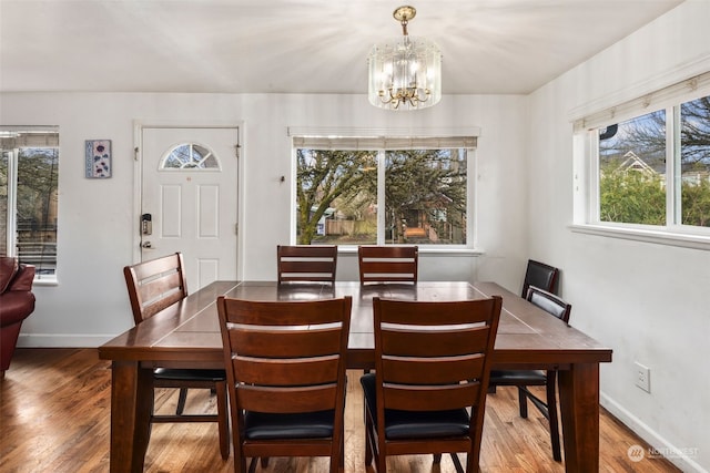 dining space with hardwood / wood-style flooring and a chandelier