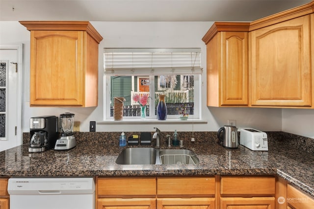 kitchen featuring white dishwasher, sink, and dark stone countertops