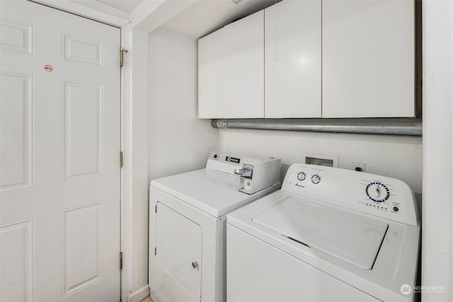 washroom featuring cabinets and separate washer and dryer