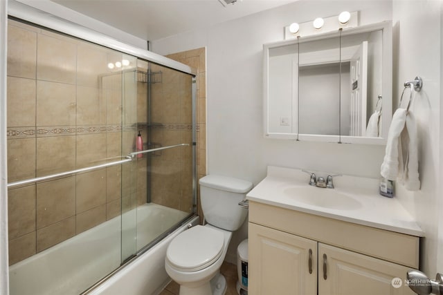 full bathroom featuring vanity, shower / bath combination with glass door, and toilet